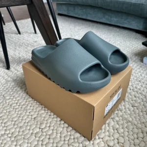 Yeezyslides  - Hej säljer dessa helt oanvända yeezyslides. De är som sagt aldrig använda så skicket är 10/10. Dem är äkta och kvitto och box ingår på köpet. Priset är inte hugget i sten. Hör av vid fler frågor