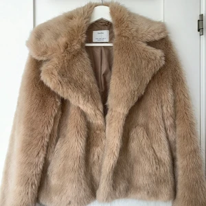 Pälsjacka  - Pälsjacka köpt här på plick men använd ca 2 gånger. Fint skick och storlek s. I vänster ficka är det ett litet hål men inget som syns och man kan fortfarande använda jackan!! 