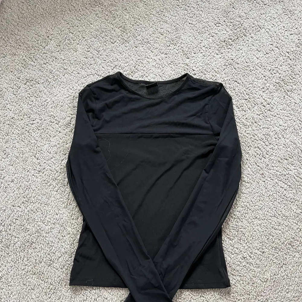 En svart blus tröja som är tunnare upptill som inte längre kommer till användning . Blusar.