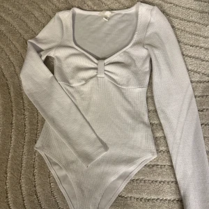 Ribbad body - Ribbad body från H&M i nyskick. Toppen sitter jättefint och formar kroppen. Den är inte alls genomskinlig. 