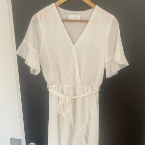 Studentklänning - Nu är det dags att sälja min fina konfirmationsklänning från förra sommaren. Klänningen har en fin volang-detalj på sidan och även en knytning i midjan. Perfekt nu inför student, konfirmation eller skolavslutning. Köparen står för frakt🌸✨