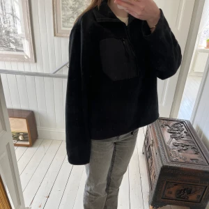 Flis - Svart flis med trekvartsdragkedja och ficka med dragkedja där fram. Flisen går även att dra in längst ner. Storleken är S men passar även M