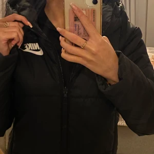 Ny Nike höst/vår jacka 2 i 1 - Jätte fin vår och höst hacka som är ny endast använd ett par gånger. Den har dubbel funktion så man kan vända jackan in och ut så har man en vind jacka med Nike märke på ryggen. Vanliga sidan är puffer jacka. Den är S, passar även XS- S/M