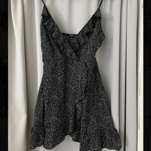 Klänning mönster - Klänning med vita små prickar och volang runt bysten., V-ringad. Tunn i tyget och slutar nedanför rumpan. Den är från shein, stl M. Liten i storlek!!😊