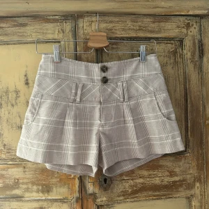 Guess shorts - Gingham shorts från Guess Jeans. Använda men i bra skick! Jättesnygga!!! Beige och vitrutiga med röd/rosa detaljer. Storlek S. 