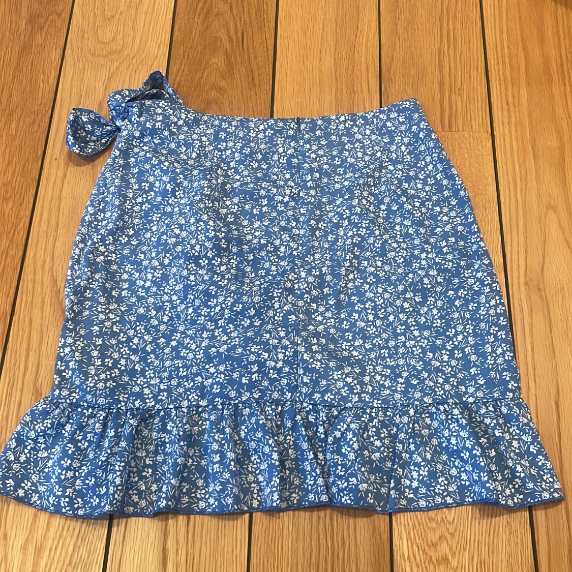 Kort blå kjol med blommor  - 90