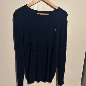 Tröja Ralph Lauren - Kabelstickad tröja från Ralph Lauren med grön häst på bröstet. Jättefint skick och storlek XL.