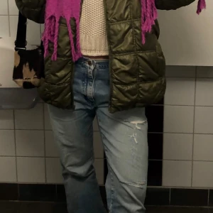 Lågmidjade jeans  - Distressed jeans, hål runt knän och baksida ficka. Passform: lågmidjade och bootcut