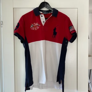 Pikétröja från Polo Ralph Lauren  - En Pikétröja från Polo Ralph Lauren i färgerna röd och vit. Relativt använd men i väldigt bra skick, nypris ca 1200. Passar perfekt nu till sommaren. PRIS ÄR DISKUTERBART!