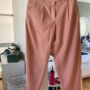 Gant byxa peach till sommaren  - Byxa från GANT aldrig använda färgen är peach. De är storlek 38 och vida ben. Byxan är 101cm långa från midjan och neråt. Har kostat 2000kr köpa förra sommaren. Aldrig använda.