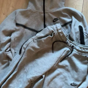 Grå Nike tech fleece  - Byxor och tröja i bra skick Settet kostar 900kr  500kr för tröja  400kr för byxorna  
