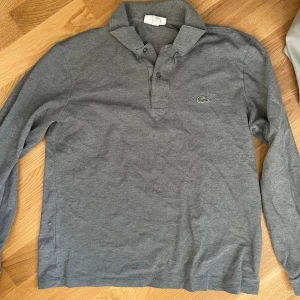 Lacoste polotröja  - Grå poloshirt i st M. Bra skick! 
