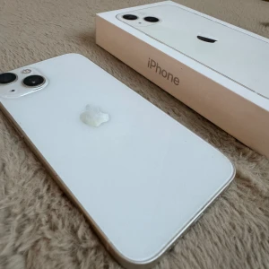 iPhone 13 Vit - Använd iPhone 13 i gott skick, finns fåtal repor som syns på bilderna. Ett använt skal från ideal of sweden medföljer om önskas, skicka pm för bilder 🩵