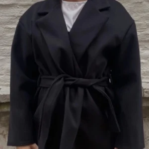 Svart kort kappa - Svart trendig kappa, kappan är helt oanvänd och är i storlek S.  