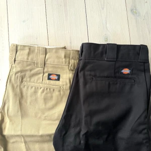 DICKIES byxor - Säljer två dickies byxor, båda i storlek W30/L32. Jag är 170cm och har vanligtvis strl 36-38 i byxor och dem passar mig bra men de kommer inte till användning. Byxorna är helt oanvända.Vet inte vad som hände med bild nr 2, de beiga är inte randiga😁