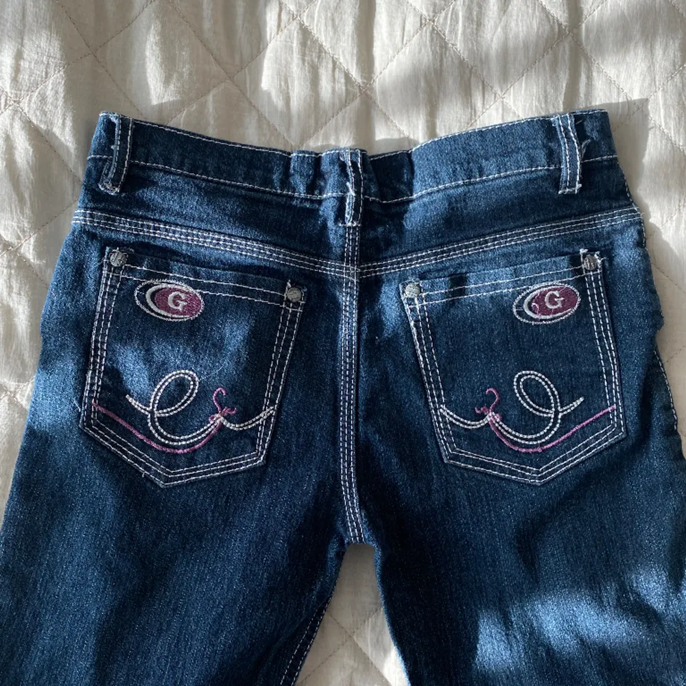 Jättesöta raka, lågmidjade mörkblå jeans med vita sömmar och snyggt rosa mönster på fickorna. Skulle säga storlek xs Längd 93  Innerbenslängd 68  Midjemått 36. Jeans & Byxor.