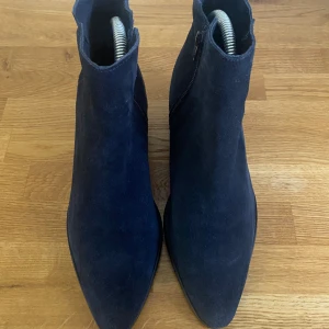 Marinblå stövletter storlek 40 - Marinblå stövletter i mocka från K.Cobler. Storlek 40. Använda ett fåtal gånger, så jättefint skick.