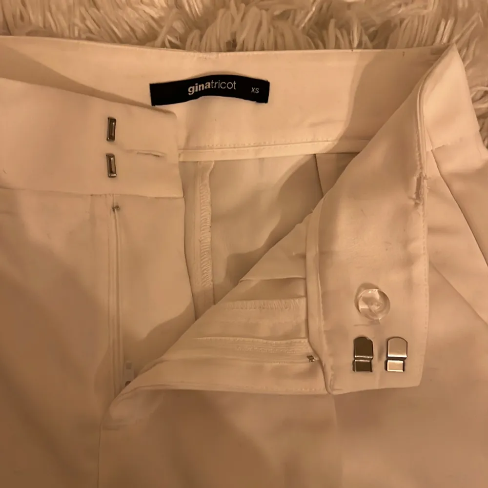 Ett par vita kostymbyxor från Gina Tricot. De är i storlek XS men skulle kunna funka som storlek S också pga den vida passformen. Väldigt bra skick, har bara används en gång.. Jeans & Byxor.