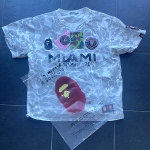 Bape t shirt  - Storlek m   Bape x miami t shirt  9/10 Vet inte riktigt om den är äkta. Kom Järna med bud eller byte   Passar m-s