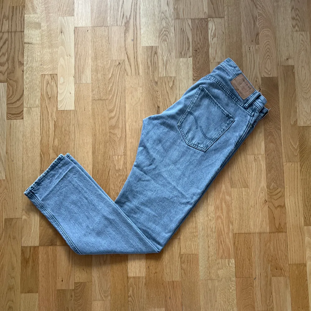 Ett par grå jeans från Jack & Jones. Relativt använda men i bra skick förutom ett litet slitage längst med vid ett av benen, därav lågt pris. Jeans & Byxor.