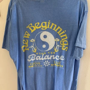 Blå t-shirt med tryck från Urban Outfitters - Oversized t-shirt med tryck från Urban Outfitters, unisex (egentligen från herr avdelningen).