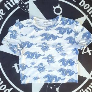 Bershka Croptop i Draketryck🐉 - Snygg crop top från Bershka med traditionell-drake tryck🐉Använd ett par gånger och är i fint skick. Inte riktigt min smak längre😅