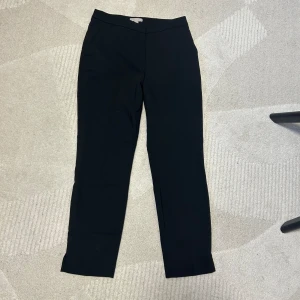 Kostymbyxor  - Säljer dessa två kostymbyxor i vit och svart. Svart i storlek 38 och vit i storlek 36. De är i nytt skick och har knappt använts. Båda byxorna är från H&M. En byxa för 150kr.  