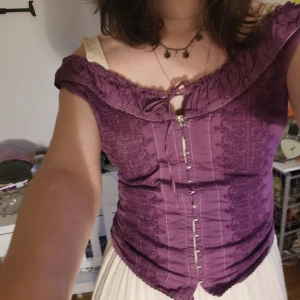 Lila broderad topp - Väldigt fin topp i lite hippie/medeltida stuk som är fyndad på Plick. Brukar ha den uppknuten där bak som i bild 1 och 2! Egentligen är den nog gjord för storlek M-L.   Bara meddela om du undrar något 🌸