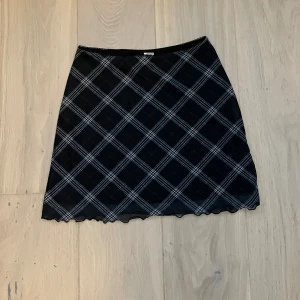 Mörkblå kjol - Säljer en superfin mörkblå och vit rutig kjol från Divided. Den har en klassisk A-linjeform och är perfekt för både vardag och fest. Kjolen är i storlek XS och har en elastisk midja för extra komfort. 