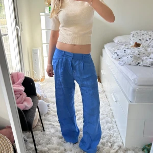 Blåa linnebyxor - Lågmidjade klarblåa linnebyxor💙💙passar nog någon som är 165-170 i längden.Lite skrynkliga efter ha legat i garderoben över vintern men har inga defekter och är i nyskick. Sista bilden visar hur de ser ut där bak. 