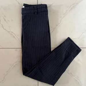 Byxor - Byxor från H&M. Dragkedja på sidan. Fejkficka bak. Fint skick. Midjemått rakt över: 33cm. Innerbenslängd: 67cm.