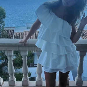 söker studentklänning  - Söker en liknade studentklänning med volanger, inga ärmar och som är kort i längden! 