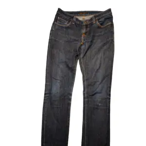 Ett par mörka Nudie Jeans i fint skick förutom lite slitage på märket bak. I strl W30/L34 