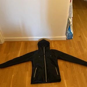 Jacka - Jacka i glansigt material i storlek M. Skön men något tajt i armarna