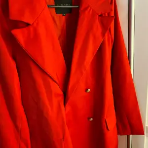 En fin röd kappa i bra skick som har används 1-2 gånger.  Storlek 38-40 (M) 