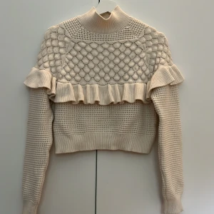 Stickad tröja - Supergullig stickad tröja med volang. Väldigt mjukt material. Köpt på sellpy men har används max 3 gånger. Ganska kort i modellen och lite högre krage💖🌷