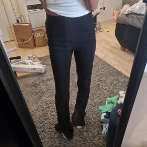 Svarta byxor - Svarta ribbade byxor med slits från Bershka! Funkar både som mjukis eller lite mer uppklätt. Storlek XS men passar XXS - S. Endast använda en gång🤍