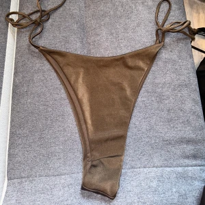 Bikiniunderdel  - Bikiniunderdel i färgen brun från Bikbok. Underdelen har justerbara knytband vid sidorna. Aldrig använd därav nyskick. Storlek L. 🤎