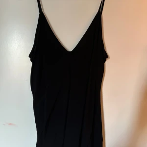 Svart linne  - Ett svart linne från &other stories med smala axelband och djup v-ringning