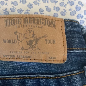 TRUE RELIGION JEANS - Ett par supersnygga riktiga true religion jeans! De är straight men skulle ändå säga att de sitter lite bootcut vid slutet de passar 13-14 åringar skulle jag säga och sitter superfint! Säljs för att de är för stora på mig!
