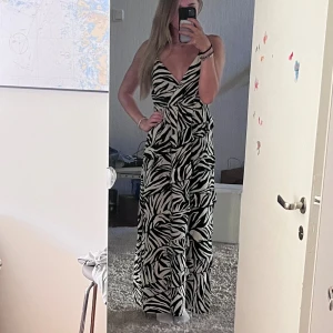 Zebra klänning - En lång zebra klänning med volanger. Aldrig använd och har kvar prislappen. Nypris 399kr. 