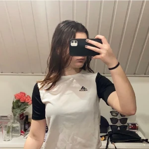 Adidas tränings tröja  - En adidas tränings t-skirt i ett tunt material som andas bra, påminner lite om en panda 