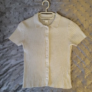 Monki tröja - Vit ribbad t-shirt från Monki med knappar. Enbart testad så i väldigt bra skick! Skriv för fler frågor eller bilder 💗 Storlek S