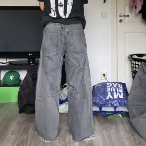 Baggy jeans - Baggy gråa jeans från H&M. Byxorna är bara lite skrynkliga men man kan stryka bort det. Avklippta av mig. Ytter/innerben längd: 100.5cm/70.5cm. Midja: ca 41cm. Benöppning: 25cm