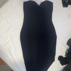 Svart klänning  - Axelbandslös, figursydd 