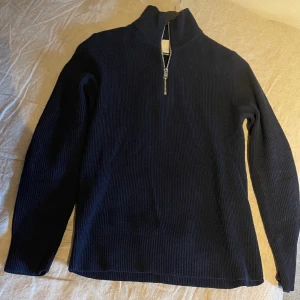 Jack & Jones Marinblå halvzip - Stilren halvzip tröja från Jack & Jones i storlek S. Nästan nyskick, bara använd cirka 2-3 gånger. Ordinarie pris 450kr.