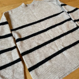 Tjock tröja stickad  - En beige tjock tröja med svarta ränder på :) Använts fåtal gånger och är i fint skick utan smuts och fläckar 🔆 Säljs då den inte kommer till användning, storleken är XS men skulle även säga att den passar storlek S med :)