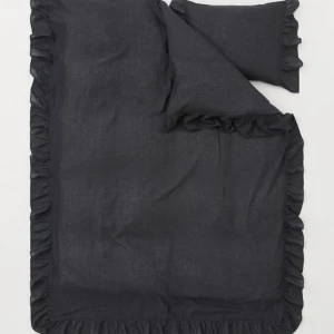 Påslakan  - 2 stycken svarta påslakan set med volanger. Köpta från H&M Home För 559 kr styck. Materialet är 70% Bomull 30% Linne. Påslakanet knäpps nedtill med knappar. 150x200 cm 50x60 cm. 
