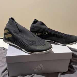 Inomhusfotbollsskor strl 44 - Ett par adidas Nemiziz som är väl använda men också välbehållna. Använd 1 säsong och har inga defekter.Priset kan diskuteras och det tas emot rimliga bud. Kan mötas upp centralt i Stockholm annars står köparen för frakten.