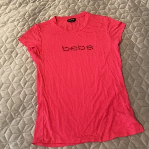 Bebe T-shirt  - Bebe T-shirt i skönt material. Använd ett fåtal gånger så väl omhändertagen. Inga stenar saknas. Köpt i New York tillsammans med en svart Huvtröja (separat annons). Nypris svårt att hitta men ligger runt 44$. Pris kan diskuteras!